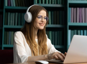 Learner with headphones writing notes while studying for CELPIP