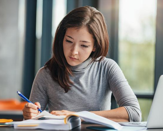 Student wearing headphones studying on a laptop for IELTS preparation